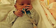 Keniya is registered to the contest to win money with this photo: baby, pacifier, headband, bow, blanket, onesie, infant, cute, sleeping_bed, soft, newborn, child, clothing, cozy, indoors, person, lying_down, hand, face, resting
