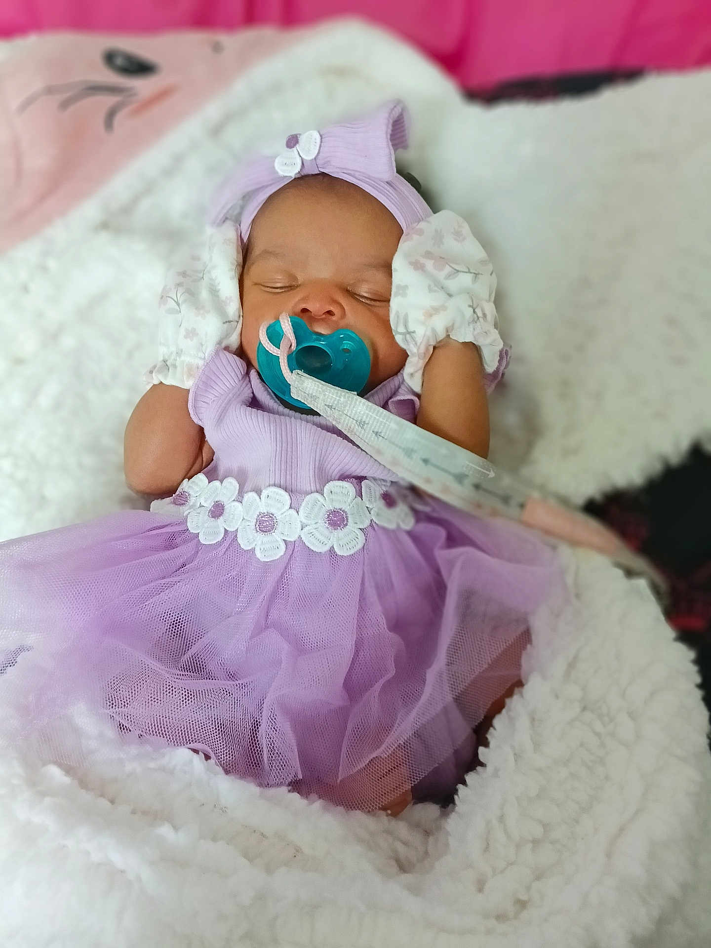 Keniya joined the competition — help win amazing prizes! baby, infant, sleeping, pacifier, lavender_dress, headband, mittens, blanket, cozy, cute, floral, tulle, soft, newborn, portrait, child, indoor, pink, white, resting