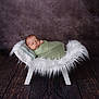 newborn, baby, sleeping, blanket, green, white, chair, fluffy, soft, cushion, wooden, floor, portrait, studio, peaceful, resting, infant, wrapped, cozy, background