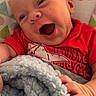 baby, infant, child, smiling, laughing, portrait, close_up, red_shirt, blanket, fluffy_blanket, sitting, baby_seat, indoors, patterned_background, happy, face, hands, family_photo, cute, photography
