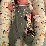 Noelani joined the competition — help win amazing prizes! baby, child, clothing, colorful, cushion, cute, indoor, infant, laying_down, lounger, minnie_mouse, mittens, newborn, onesie, person, portrait, rainbow_pattern, resting, sleepwear, soft_toys