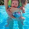 adult, arms, baby, blue_eyes, child, greenery, holding, legs, nature, outdoor, person, reflection, relaxation, skin, summer, sunlight, swimming_pool, swimsuit, vacation, water