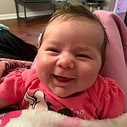 Noelani joined the competition — help win amazing prizes! baby, smiling, pink_clothing, blanket, indoor, face, child, happy, person, couch, furniture, television, wood_floor, window, head, cozy, portrait, infant, cute, home