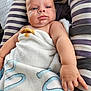 Giorgio participe au concours pour gagner de l'argent avec cette photo : baby, blanket, cushion, striped, infant, skin, face, hand, fingers, blue_eyes, soft_texture, comfort, seated, indoors, closeup, expression, person, child, young, cute