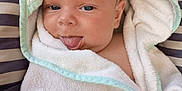 Giorgio participe au concours pour gagner de l'argent avec cette photo : baby, child, towel, hooded_towel, tongue_out, playful, cute, striped_cushion, infant, face, skin, blue_eyes, blanket, wrapped, young, person, soft_texture, relaxed, indoors, smiling