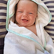 Giorgio participe au concours pour gagner de l'argent avec cette photo : baby, smiling, towel, hooded_towel, striped_background, infant, happy, cute, child, soft_texture, wrapped, portrait, indoor, comfort, young_child, cozy, face, head, skin, person