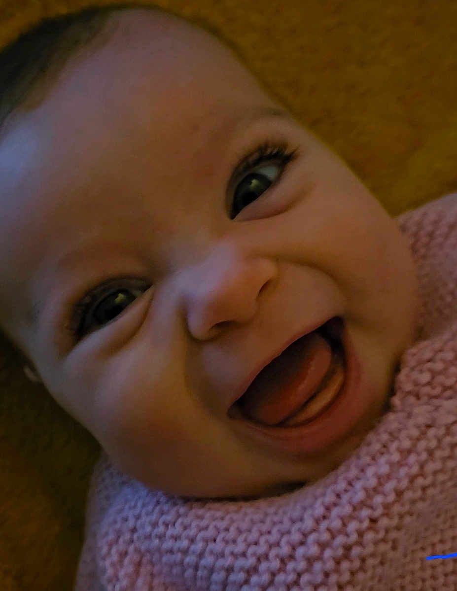 Sofia participe au concours pour gagner de l'argent avec cette photo : baby, child, face, smile, happy, closeup, infant, knitted_sweater, pink_clothing, yellow_background, mouth_open, tongue_out, cute, joyful, expression, eyelashes, skin, head, portrait, indoors