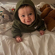 Leeroy participe au concours pour gagner de l'argent avec cette photo : baby, blanket, child, cozy, crawling, cute, expression, face, floor, happy, hoodie, indoor, infant, person, playtime, plush_toy, smile, soft_toy, warm_lighting, young_child