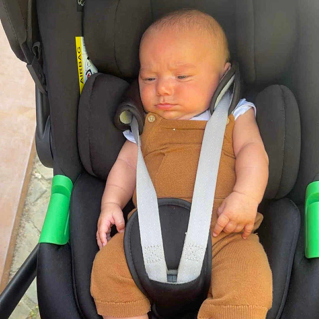 Slouma participe au concours pour gagner de l'argent avec cette photo : baby, barefoot, black_stroller, brown_clothing, car_seat, child, cute, face, frown, head, infant, outdoor, pavement, person, safety_harness, sitting, small_feet, straps, stroller, wheel