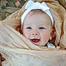 Ryleigh is registered to the contest to win money with this photo: baby, background, beige, blue_eyes, child, closeup, cloth, cozy, cute, face, happy, headband, infant, person, portrait, smile, soft, texture, wood, wrapped