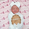 newborn, baby, infant, sleeping, white_bow, headband, blanket, pink_blanket, bows, soft_texture, wooden_sign, name_sign, wrapped, portrait, cute, peaceful, child, indoors, cozy, resting