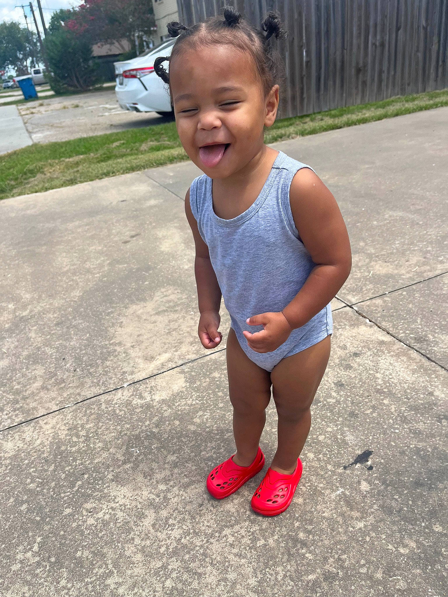 Ricky is registered to the contest to win money with this photo: asphalt, baby_toddler_clothing, car, eye, face, grass, happy, head, human_body, knee, leisure, person, plant, recreation, smile, t_shirt, thigh, toddler, tree, waist