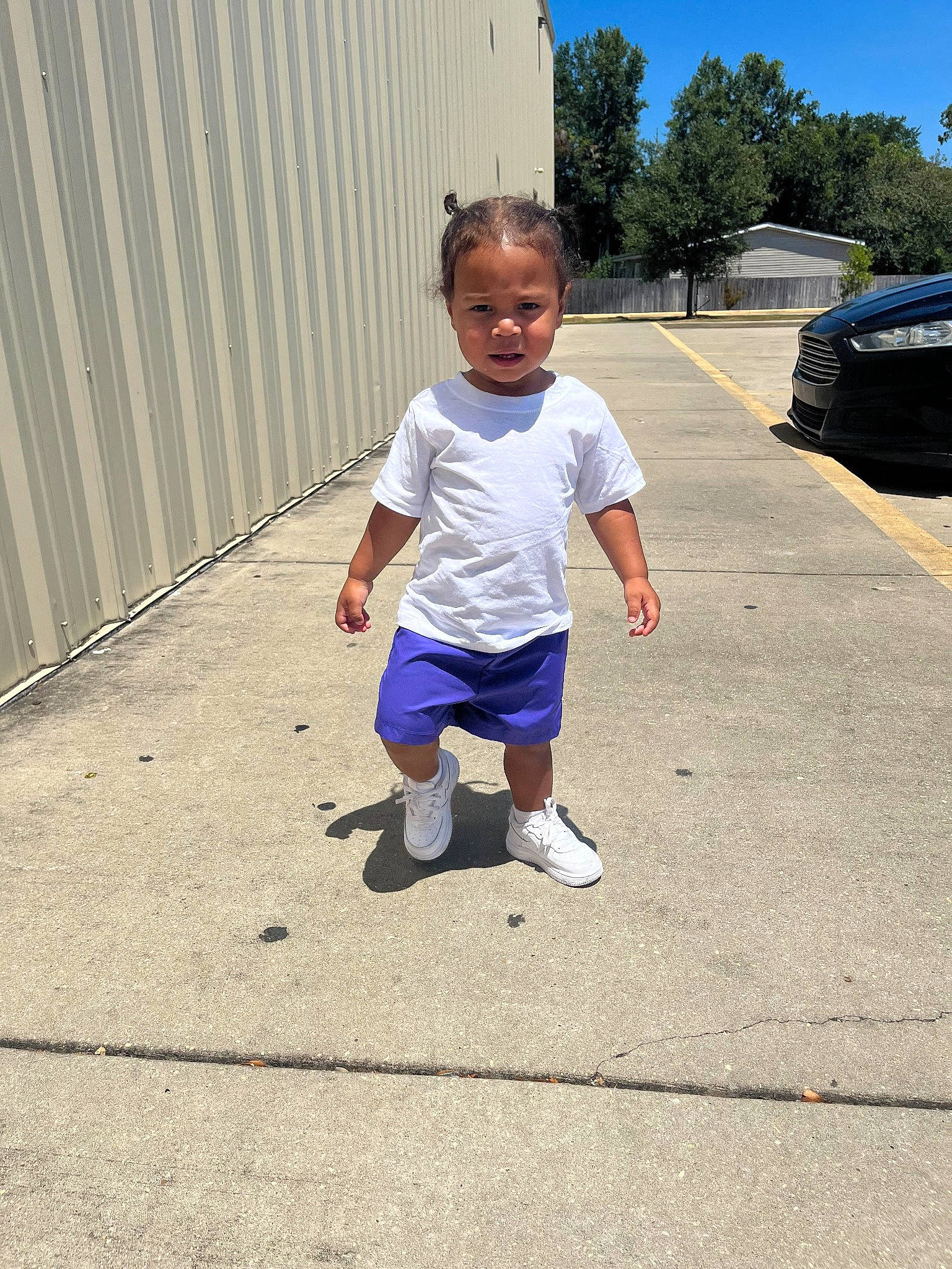 Ricky is registered to the contest to win money with this photo: asphalt, child, concrete, denim, driveway, electric_blue, human_leg, leisure, pedestrian, person, recreation, road, road_surface, roof, shorts, sidewalk, sky, soil, t_shirt, toddler