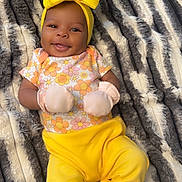 Reigh'Lynn is registered to the contest to win money with this photo: baby, smile, yellow_bow, mittens, floral_top, yellow_pants, blanket, striped_blanket, infant, happy, lying_down, cute, headband, cozy, soft, child, portrait, apparel, indoor, person