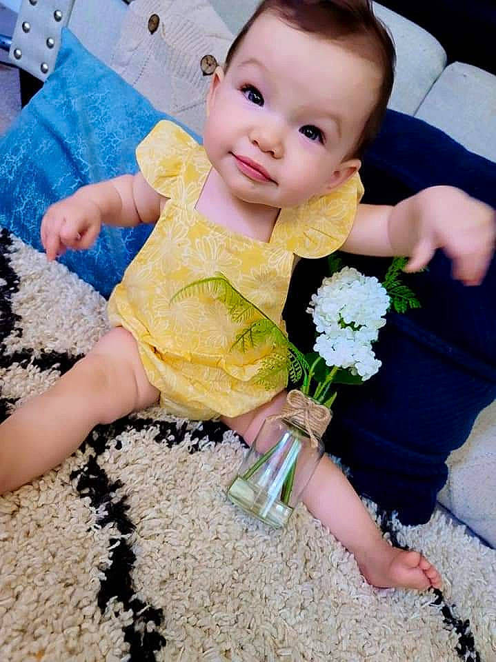 Annalise is registered to the contest to win money with this photo: baby, baby_toddler_clothing, beauty, blue, child, finger, flower, gesture, grass, hand, happy, people, people_in_nature, person, petal, photograph, plant, skin, smile, summer