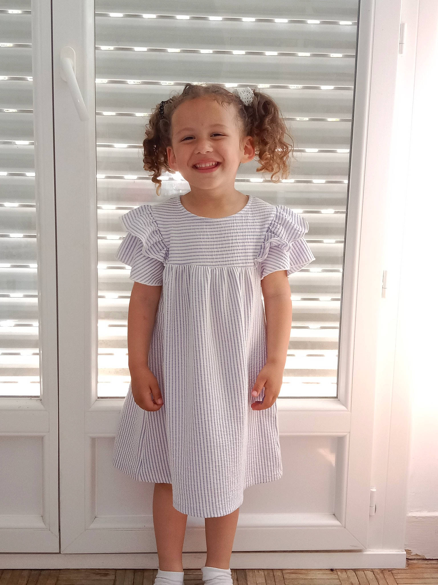 Aliyaah a rejoint le concours — aidez-le/la à gagner de superbes lots ! day_dress, door, dress, face, fashion_design, hair, human_leg, joint, joy, knee, neck, one_piece_garment, pattern, person, shoulder, sleeve, smile, toddler, trunk, vintage_clothing