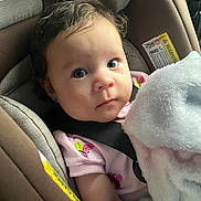 Nyella is registered to the contest to win money with this photo: baby, child, car_seat, blanket, infant, face, seatbelt, clothing, pink, cute, portrait, indoor, young, person, sitting, hair, skin, eyes, expression, soft