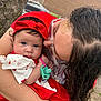 baby, child, woman, glasses, red_clothing, headband, pacifier, tree, outdoor, affection, curly_hair, holding, kiss, face, portrait, emotion, car, brick_wall, nature, closeup