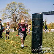Malachi is registered to the contest to win money with this photo: child, running, sports, outdoor, grass, tree, field, practice, team, coach, activity, sunny, people, athlete, training, exercise, hoodie, shorts, shoes, ladder