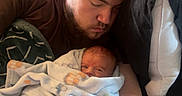 Rylan joined the competition — help win amazing prizes! baby, blanket, couch, face, father, furniture, infant, man, nap, person, portrait, rest, sleep, swaddle, toddler, young_adult, indoors, cozy, love, family