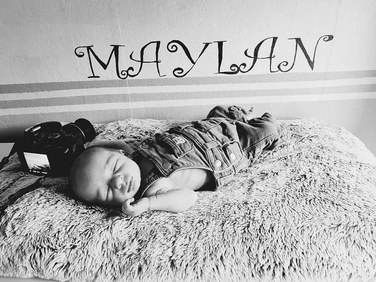 Maylan participe au concours pour gagner de l'argent avec cette photo : black_and_white, child, comfort, facial_expression, flash_photography, flooring, font, fur, grass, happy, monochrome, monochrome_photography, person, photo_caption, room, sitting, smile, stock_photography, style, toddler
