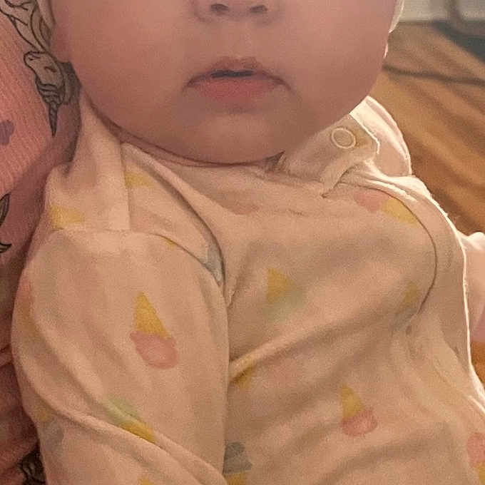 Olivia is registered to the contest to win money with this photo: baby, infant, headband, bow, onesie, pastel_colors, indoor, person_holding, curious_expression, wide_eyes, hand, soft_lighting, child, cute, portrait, clothing, skin, face, young_child, human