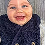 baby, smile, blue_eyes, knit_hat, vest, button, face, cheek, skin, clothing, warm, happy, child, infant, portrait, cute, closeup, indoors, person, headwear
