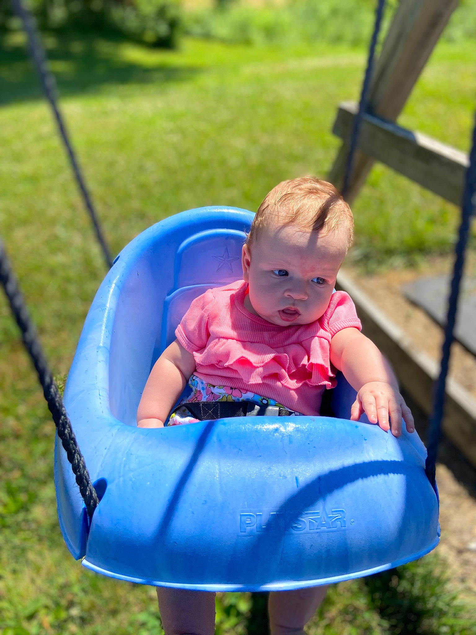 Khaleesi is registered to the contest to win money with this photo: baby, baby_toddler_clothing, child, comfort, eye, fun, grass, green, happy, leisure, mammal, outdoor_play_equipment, people_in_nature, person, photograph, product, recreation, summer, sunlight, swing
