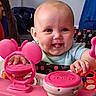 Thea joined the competition — help win amazing prizes! baby, child, tongue_out, toy, pink, disney, activity_center, smiling, indoor, cute, person, face, hand, playful, infant, furniture, colorful, happy, seat, clothing