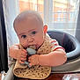 Edmond participe au concours pour gagner de l'argent avec cette photo : baby, bib, bracelet, chewing, child, close_up, curtains, cute, expression, face, furniture, high_chair, indoors, infant, natural_light, person, skin, table, teething_toy, window