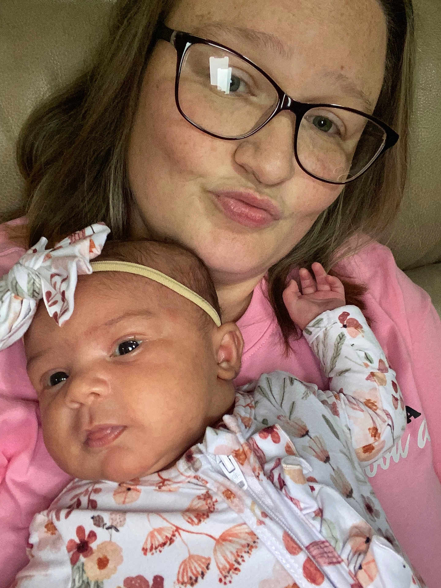 Mckinlee is registered to the contest to win money with this photo: baby, child, closeup, couch, expression, face, family, floral_clothing, glasses, head, headband, holding, indoor, love, person, pink_shirt, portrait, skin, smile, woman