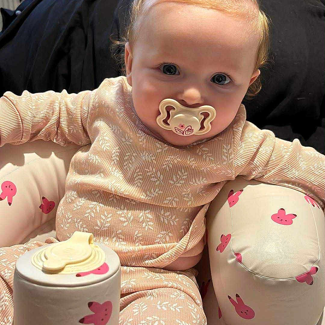 Isla-Ro joined the competition — help win amazing prizes! baby, bunny_pattern, child, clothing, comfort, container, cushioned_seat, cute, face, hair_buns, indoor, infant, pacifier, pajamas, person, pink, relaxed, seat, small, toy