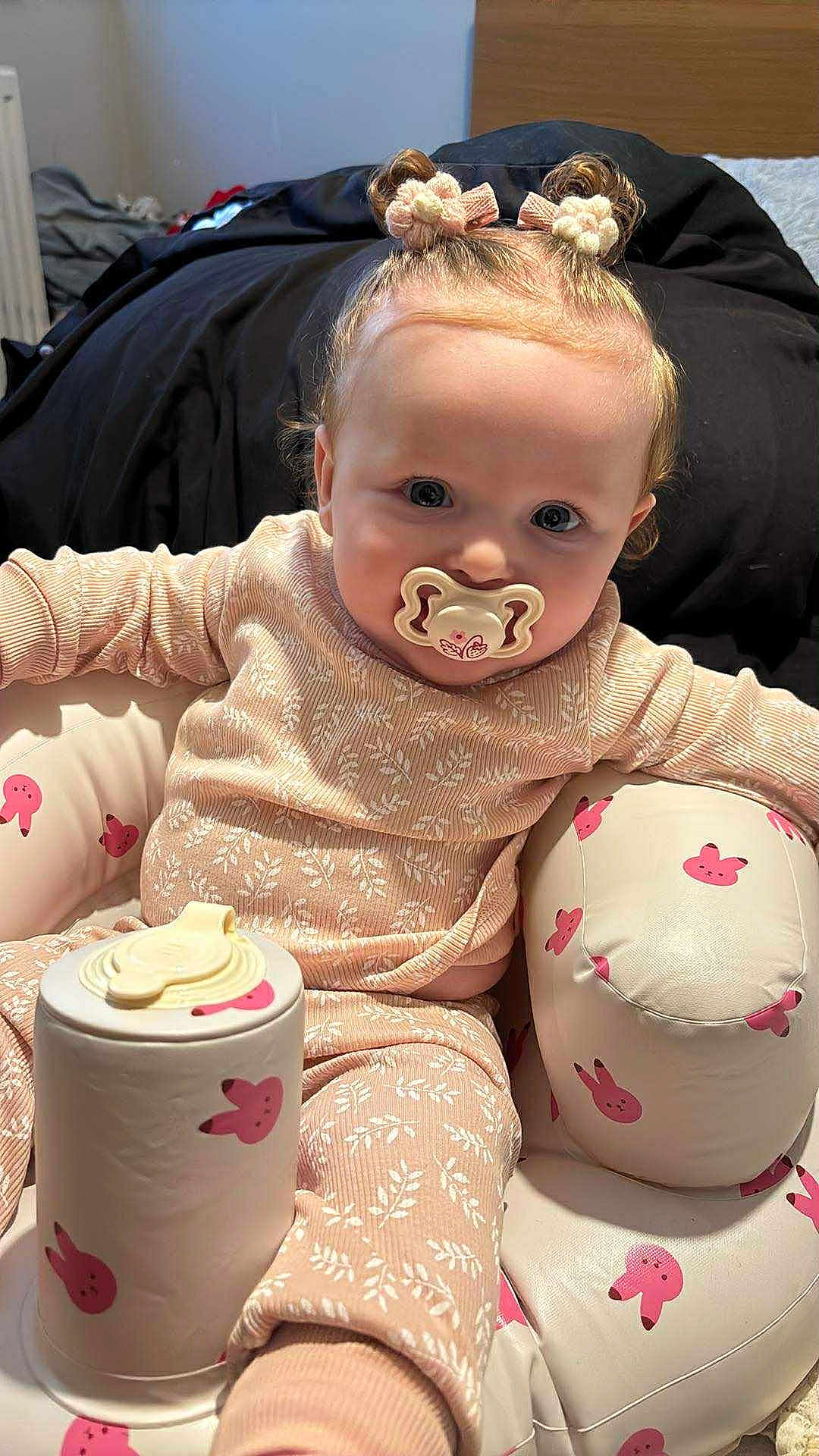 Isla-Ro joined the competition — help win amazing prizes! baby, pacifier, pajamas, hair_buns, pink, bunny_pattern, cushioned_seat, container, indoor, child, cute, infant, clothing, face, person, seat, toy, comfort, relaxed, small