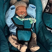 Blu is registered to the contest to win money with this photo: newborn, baby, sleeping, car_seat, knit_hat, pacifier, baby_clothing, infant, blue, teal, strap, cute, cozy, indoors, child, soft, peaceful, wrapped, small, wearing_hat
