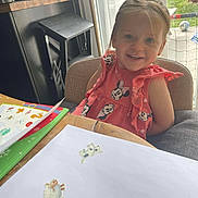 Athena participe au concours pour gagner de l'argent avec cette photo : chair, child, clothing, curtains, face, garden, happy, home, indoor, minnie_mouse, paper, person, playtime, smiling, stickers, sunlight, table, toddler, window, wooden_furniture