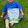 Malachi joined the competition — help win amazing prizes! child, boy, grass, certificate, book, blue_shirt, gray_shorts, socks, outdoor, summer, expression, sitting, funny_face, casual, playful, nature, greenery, award, reading, daylight