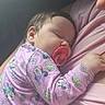 baby, sleeping, pacifier, pink_clothing, onesie, person, child, infant, cute, resting, toddler, mickey_mouse, soft_light, closeup, comfort, cuddling, nap, indoor, portrait, peaceful