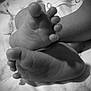 baby, feet, toes, black_and_white, closeup, skin, wrinkles, fabric, snap_buttons, texture, infant, small, soft, resting, monochrome, detail, newborn, foot, human, body_part