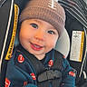 Maverick is registered to the contest to win money with this photo: baby, child, infant, smiling, portrait, car_seat, vehicle,  안전, beanie, pom_pom, football_pattern, sportswear, harness, seated, indoor, close_up, face, happy, road_trip, photography