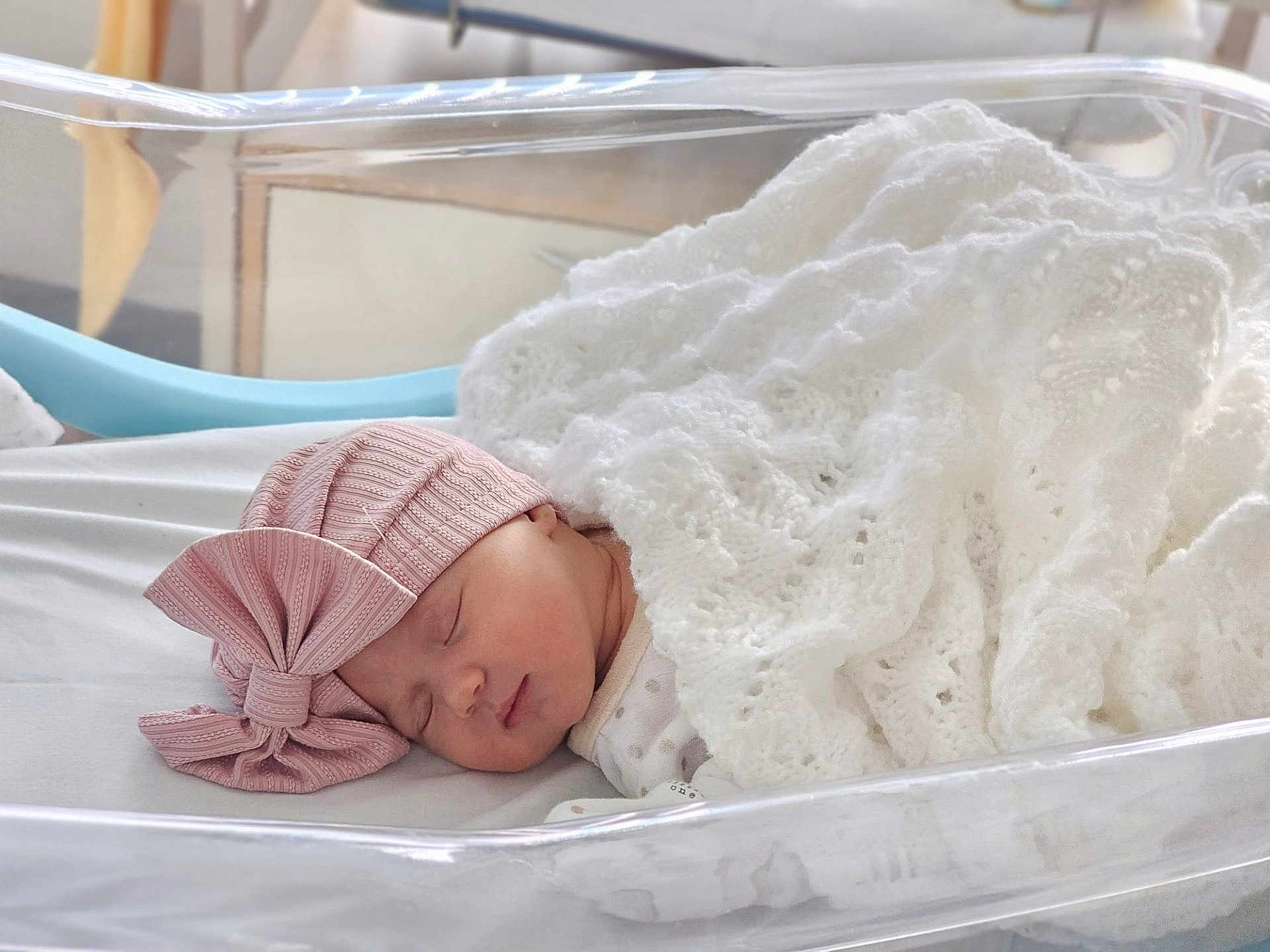 Emilia joined the competition — help win amazing prizes! newborn, baby, sleeping, blanket, pink_hat, bow, bassinet, hospital, infant, cute, peaceful, soft_lighting, white_blanket, wrapped, resting, closeup, face, headwear, indoors, portrait