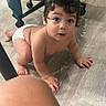baby, infant, child, crawling, diaper, curious, wide_eyes, portrait, indoor, floor, wood_floor, office_chair, furniture, home, hands, feet, dark_hair, sitting, surprised, photography