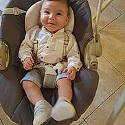 Kayden a rejoint le concours — aidez-le/la à gagner de superbes lots ! baby, child, smiling, sitting, baby_swing, white_shirt, striped_shorts, suspenders, indoor, floor_tiles, plush_toy, baby_shoes, person, cute, infant, happy, portrait, clothing, seat, hands