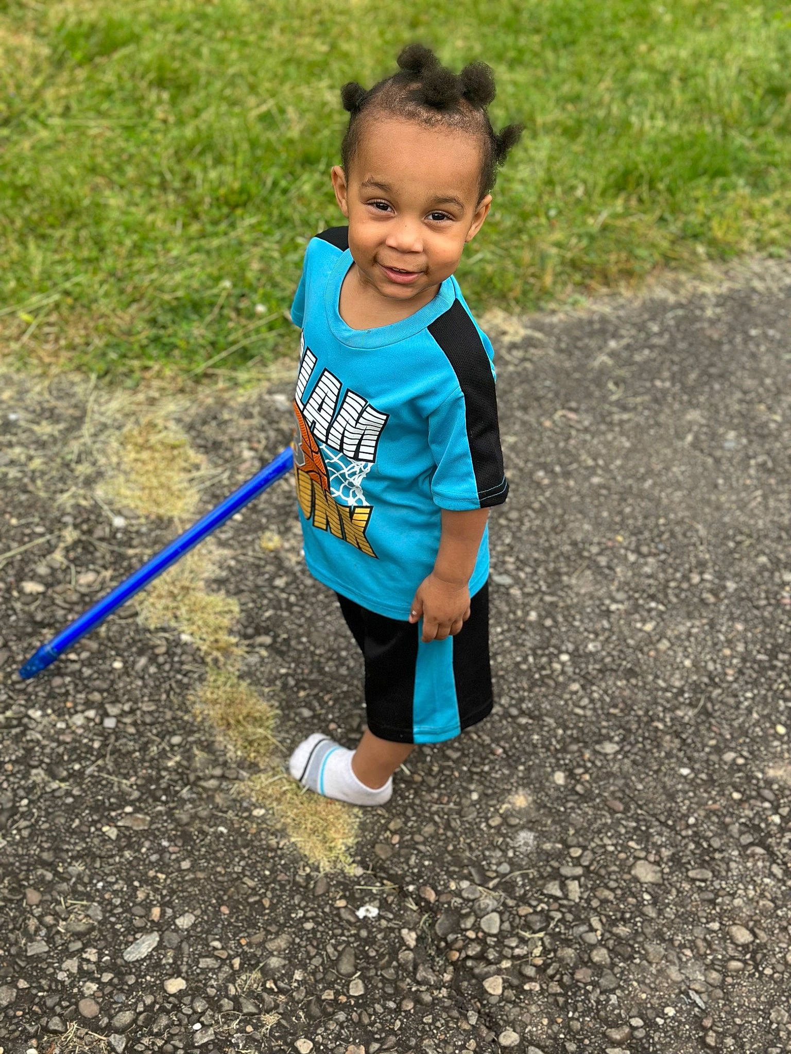 Lorenzo is registered to the contest to win money with this photo: asphalt, child, electric_blue, fun, grass, grassland, happy, joy, leisure, outdoor_play_equipment, people_in_nature, person, play, recreation, shorts, smile, sneakers, soil, t_shirt, toddler