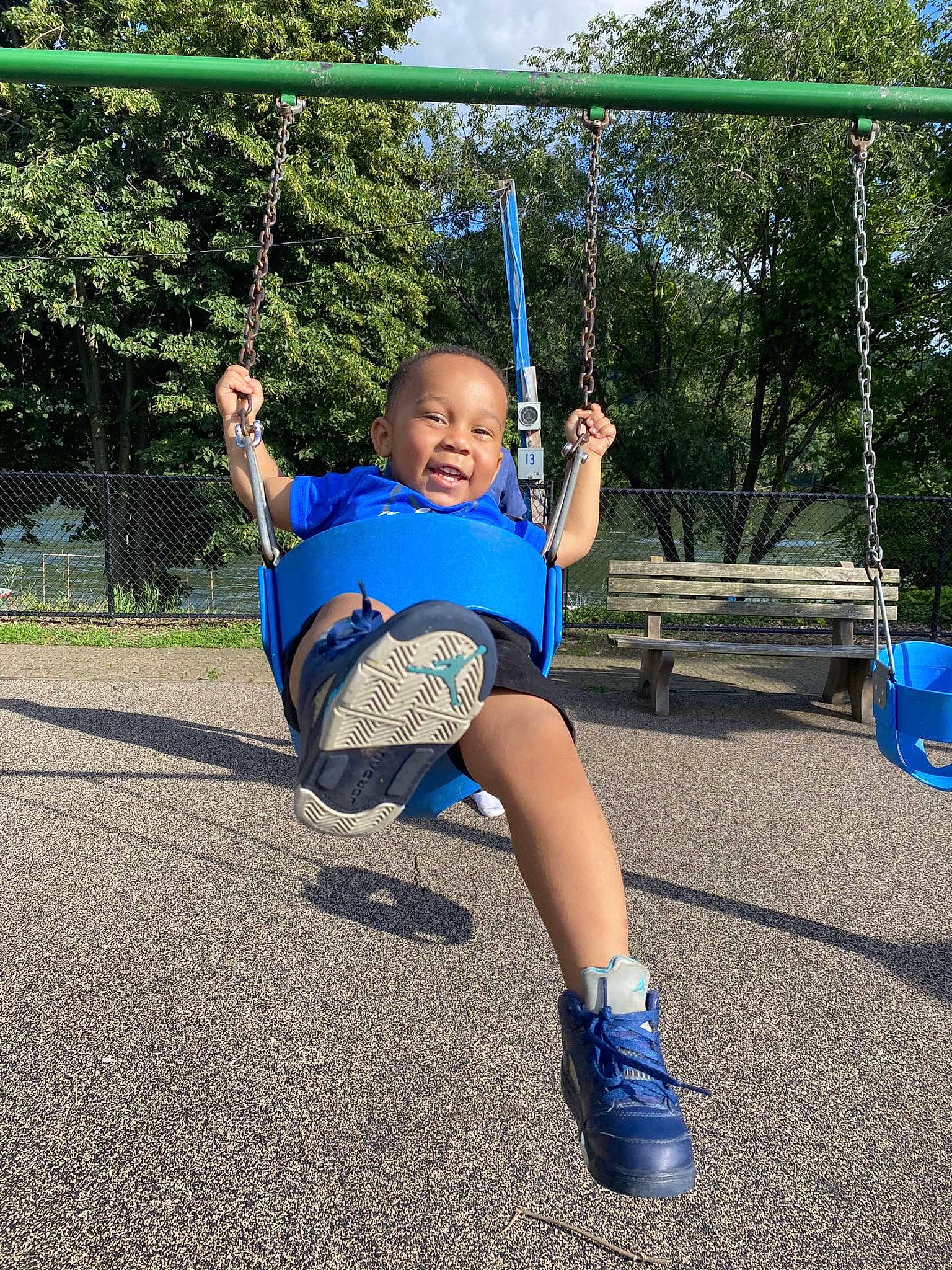 Lorenzo is registered to the contest to win money with this photo: city, electric_blue, fun, grass, happy, knee, leisure, outdoor_play_equipment, person, plant, play, playground, public_space, recreation, shade, shorts, smile, swing, t_shirt, toddler