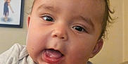 Kyree joined the competition — help win amazing prizes! baby, child, face, hand, mickey_mouse, shirt, person, portrait, smile, indoors, wall, photography, young_child, holding_hand, cute, expression, infant, baby_clothes, human, closeup