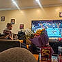 Kyree joined the competition — help win amazing prizes! baby, man, couch, living_room, television, wrestling, flowers, bouquet, snack_box, photograph_frames, speaker, chair, person, watching_tv, indoor, furniture, family, casual, relaxation, home