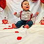 child, baby, infant, smiling, barefoot, suspenders, striped_shirt, jeans, heart_balloon, valentine_decor, red_beads, tinsel, white_backdrop, rose_petals, party, portrait, celebration, indoor, cheerful, balloon