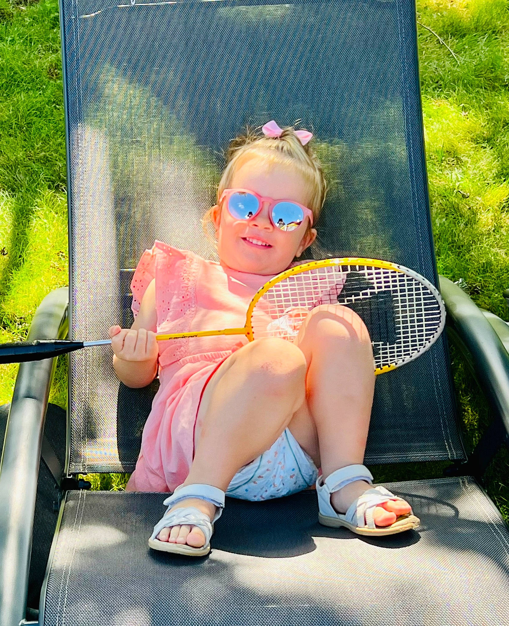 Lya a rejoint le concours — aidez-le/la à gagner de superbes lots ! chair, child, electric_blue, eyewear, fun, goggles, grass, happy, human_leg, joy, lap, leg, leisure, person, personal_protective_equipment, recreation, sitting, sneakers, sunglasses, thigh