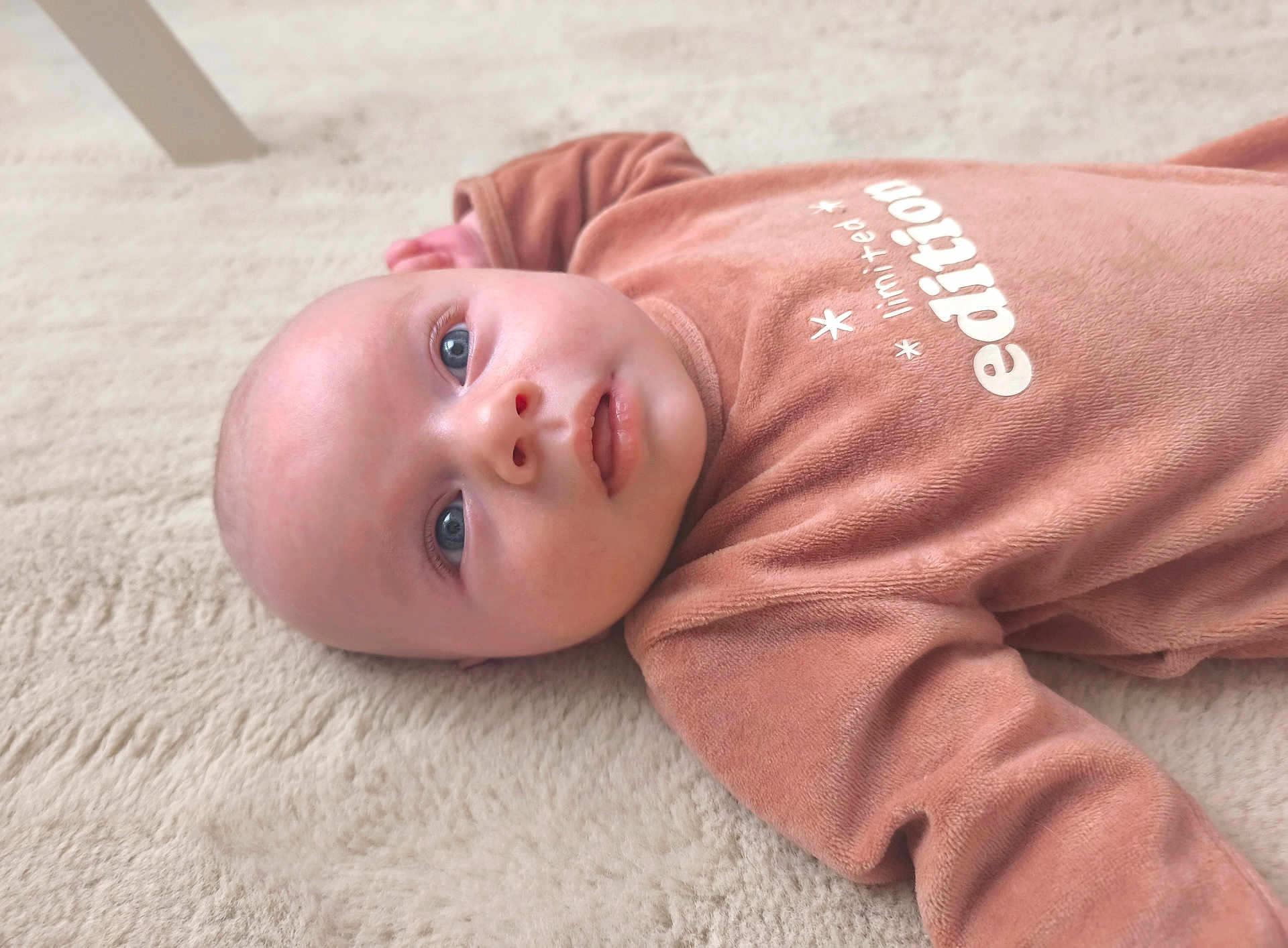 Octave participe au concours pour gagner de l'argent avec cette photo : baby, infant, newborn, lying, carpet, onesie, clothing, portrait, close_up, face, head, eyes, cheeks, mouth, skin, cute, indoor, soft_texture, blanket, gaze