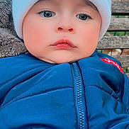 Jerry participe au concours pour gagner de l'argent avec cette photo : baby, child, face, hat, knit_hat, blue_jacket, zipper, bench, wood, outdoor, cute, portrait, winter_clothing, warm, childhood, expression, young, infant, cozy, serious